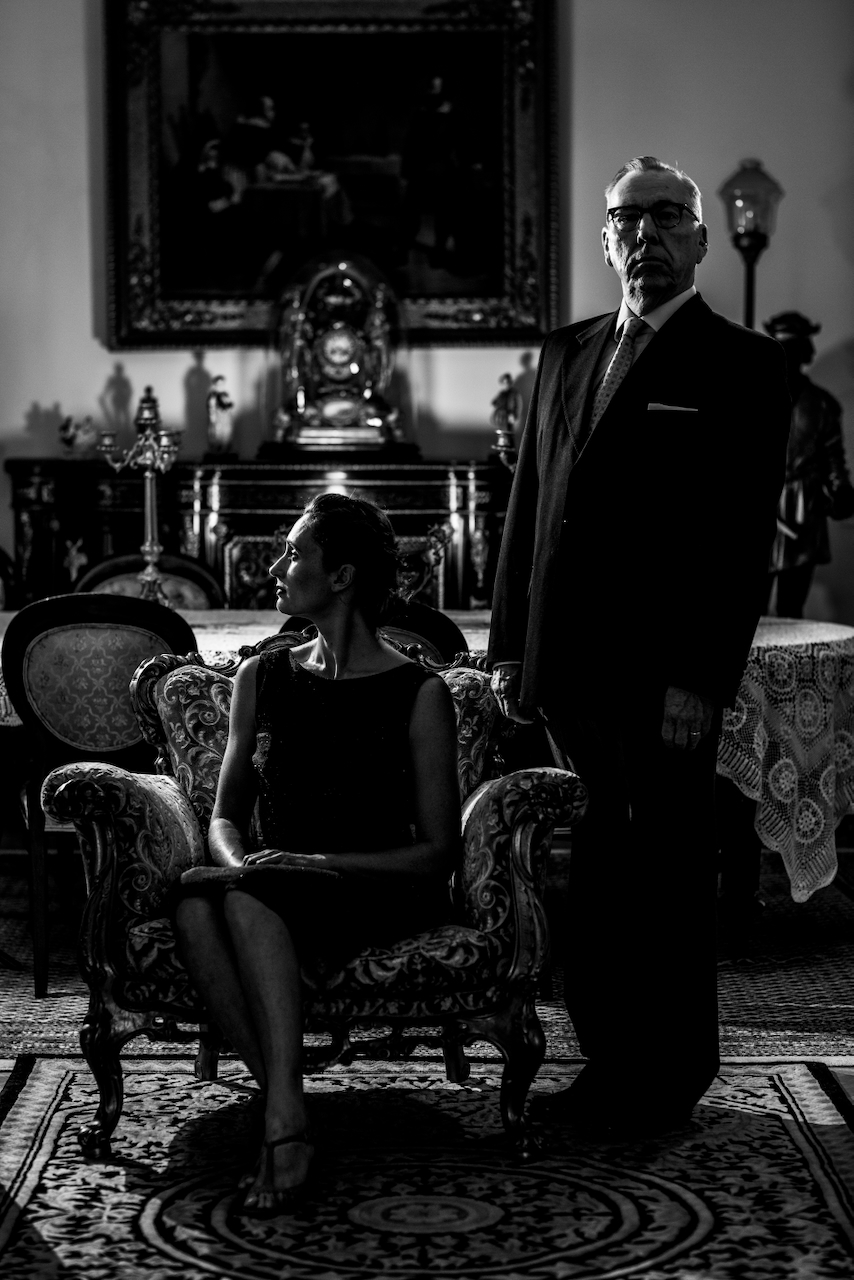 A couple posed in an ornate room