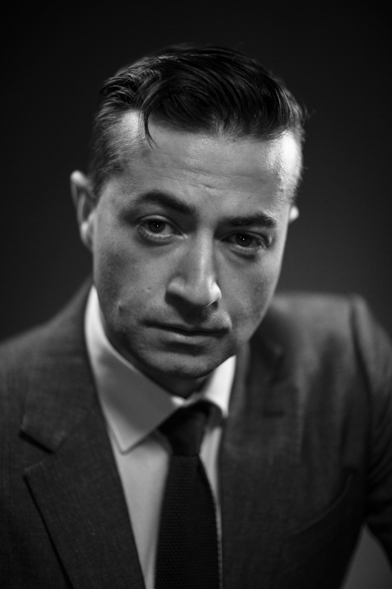 A close black-and-white portrait of a man in a suit