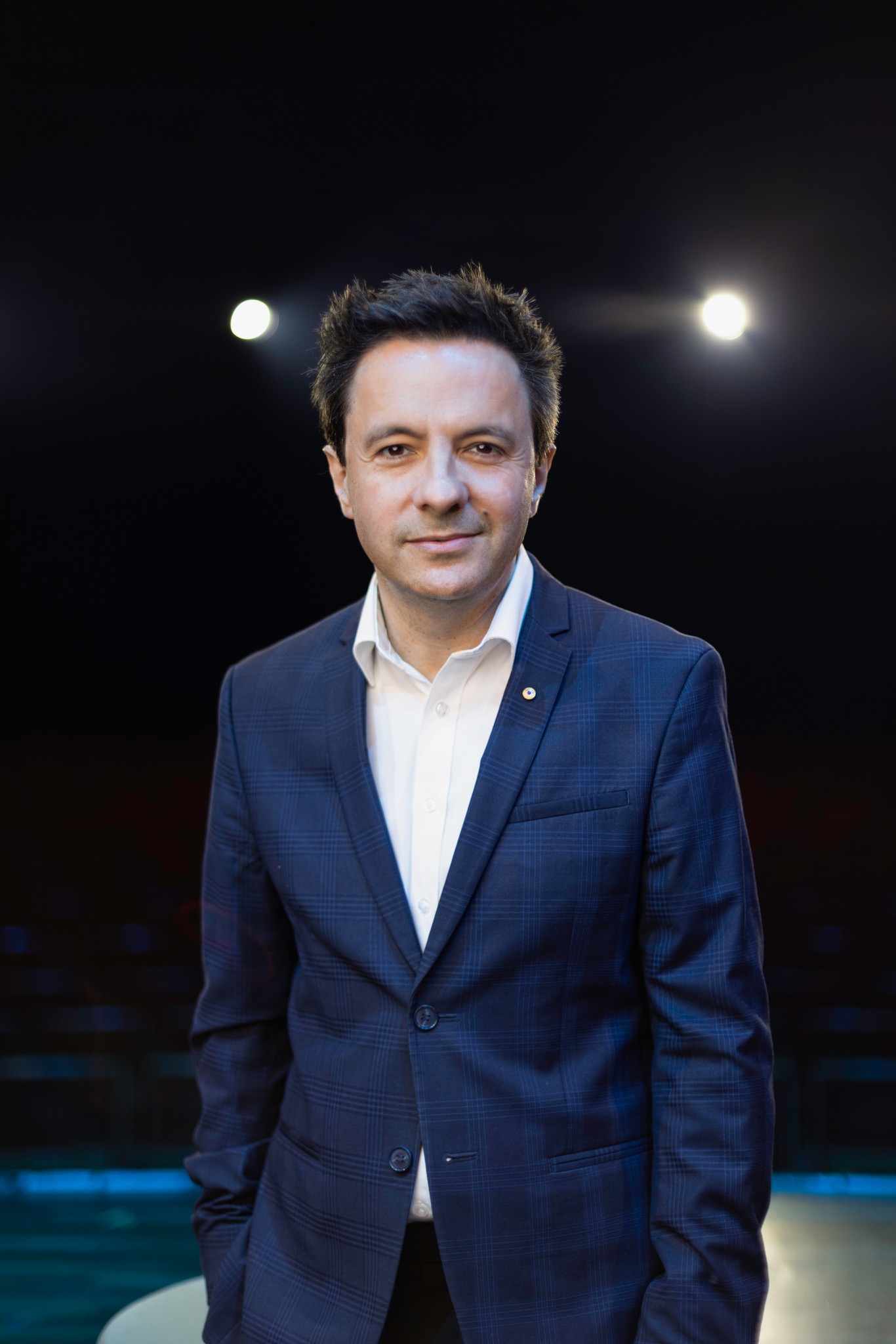 A man in a blue suit in a theatre