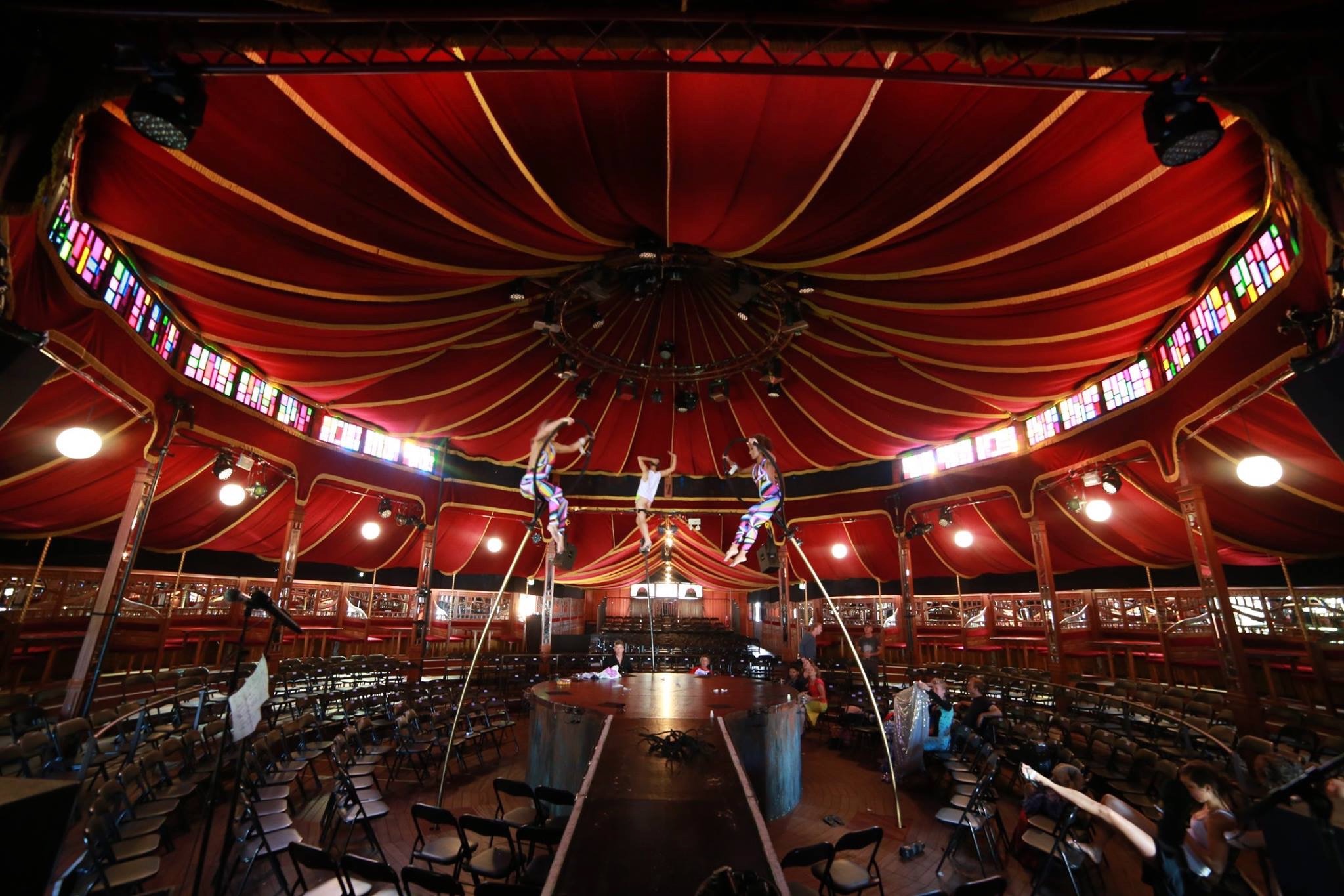 Performers rehearsing beneath a red circular tent